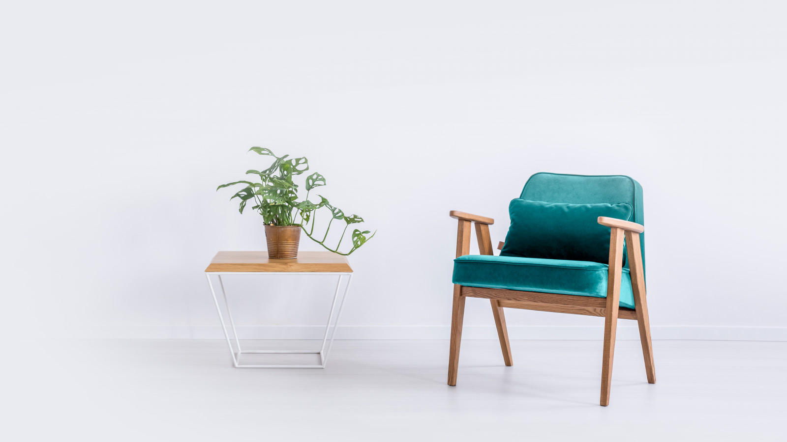 Sillon de color verde sobre fondo gris y mesita con flores para Tasación de vivienda gratis