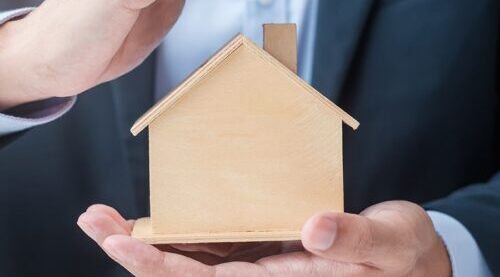 Gestor inmobiliario protegiendo un hogar de venta de inmuebles por herencias