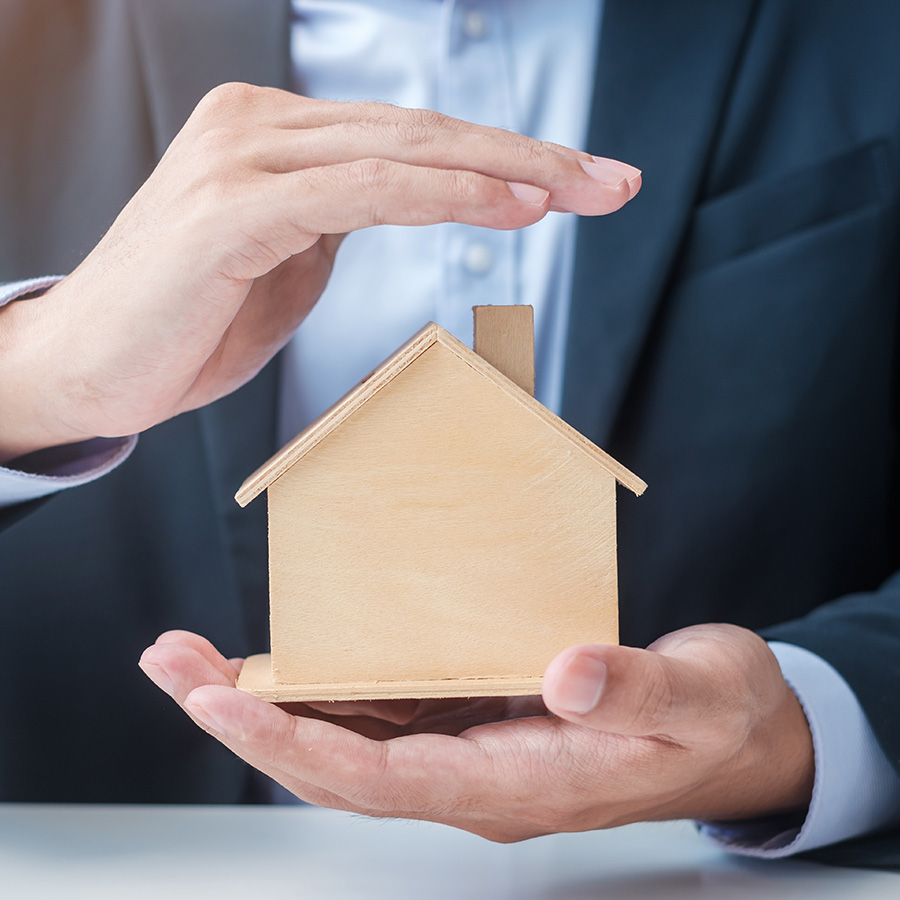 Gestor inmobiliario protegiendo un hogar de venta de inmuebles por herencias