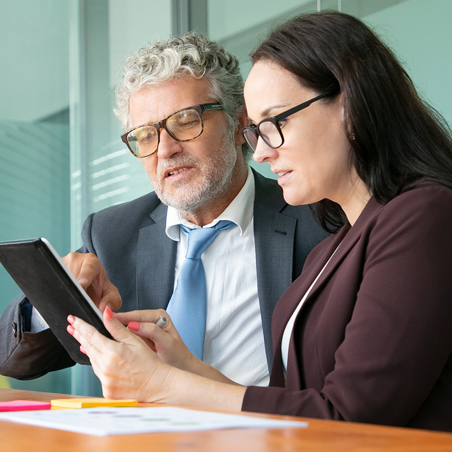 Un hombre y una mujer en traje de negocios realizan asesoramiento financiero inmobiliario